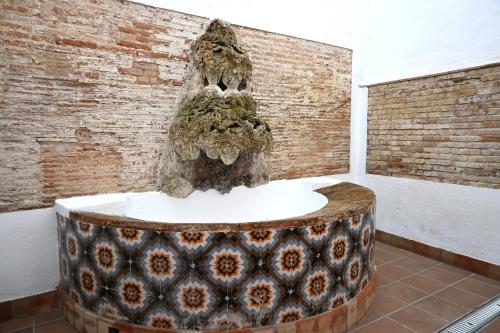 a fountain in a room with a brick wall at Homenfun Dalt Badalona in Badalona