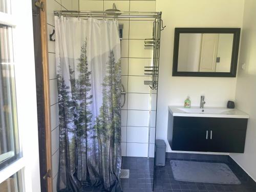 a bathroom with a shower curtain with a sink at Kopli puhkemaja Saaremaal in Kasti