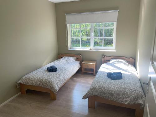 two beds in a small room with a window at Kopli puhkemaja Saaremaal in Kasti