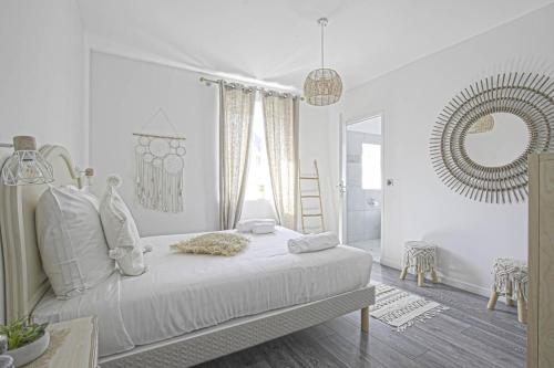 une chambre blanche avec un lit et un miroir dans l'établissement Villa d'exception au coeur de Deauville, Jardin & Cinéma privé, à Deauville