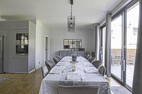 une salle à manger avec une longue table et des chaises dans l'établissement Villa d'exception au coeur de Deauville, Jardin & Cinéma privé, à Deauville