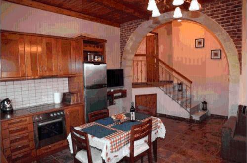 a kitchen with a table and a kitchen with a staircase at Metochi Villas in Spílion