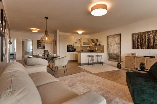 a living room with a couch and a dining room at Seeloft - Boutique Apartments Am See in Fulda
