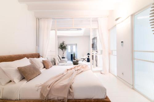 a white bedroom with a large bed with white walls at Plaka Villa with Epic Acropolis Views in Athens