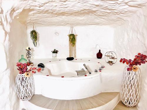 a white bath tub in a room with two vases at Casa Rural Las Colmenas in Alcalá del Júcar