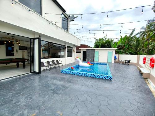 a swimming pool with a swan in the middle of a house at SunsetChalet 25pax Pool Snooker Bathtub Playground in Kluang