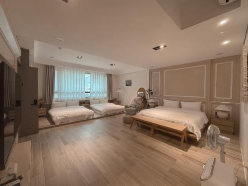 ein großes Schlafzimmer mit 2 Betten und einem Sofa in der Unterkunft Good Day B&B in Magong