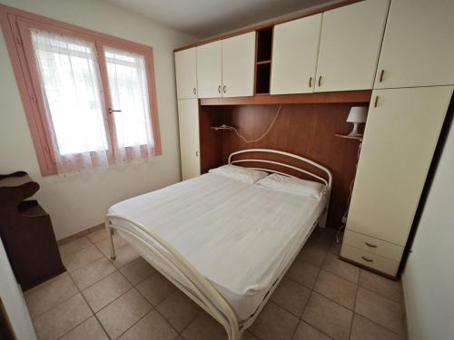 a small bedroom with a bed and a window at Lara in Rosolina