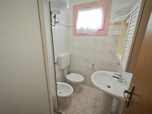 a small bathroom with a toilet and a sink at Lara in Rosolina