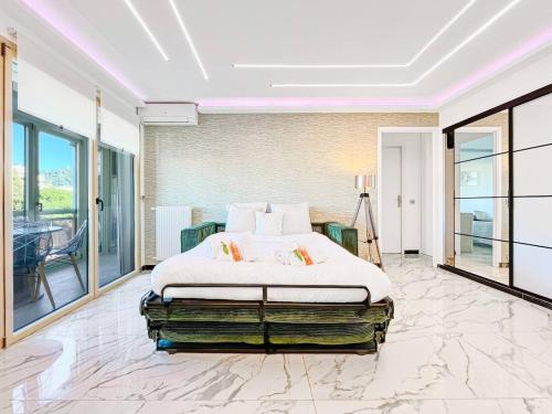 - une chambre avec un lit dans une pièce dotée de grandes fenêtres dans l'établissement Le Mimosa - Accommodation Patio Centre de Cannes, à Cannes