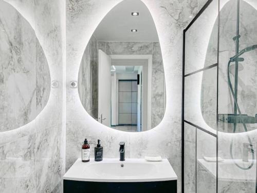 une salle de bain avec un lavabo et un miroir dans l'établissement Le Mimosa - Accommodation Patio Centre de Cannes, à Cannes