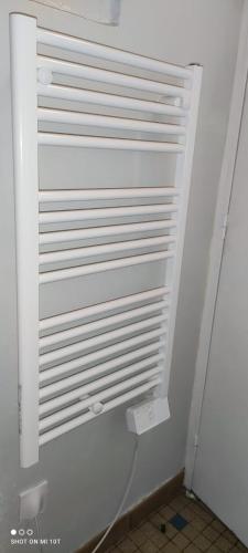 La salle de bains est pourvue d'un mur blanc et de toilettes. dans l'établissement Studio aux portes de Paris, très bien desservi par les transports, à Fontenay-sous-Bois