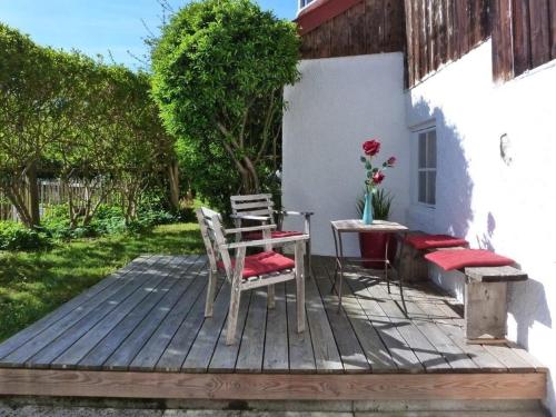 two chairs and a table on a wooden deck at Freiraum Ferienwohnung in Dießen am Ammersee