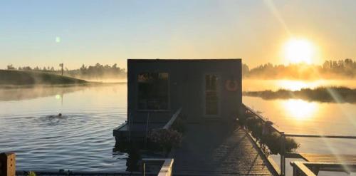 a building in the middle of a body of water at Atpūtas māja "Rūdupji" in Gulbene