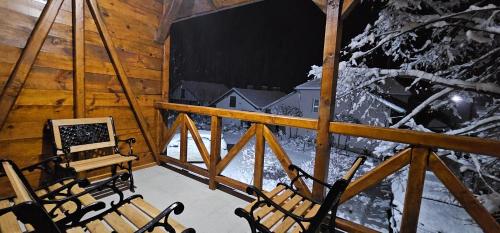 a room with chairs in a cabin with a winter view at Etno selo Katunija in Katun