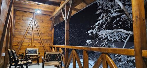 a porch of a cabin with a table and chairs at Etno selo Katunija in Katun