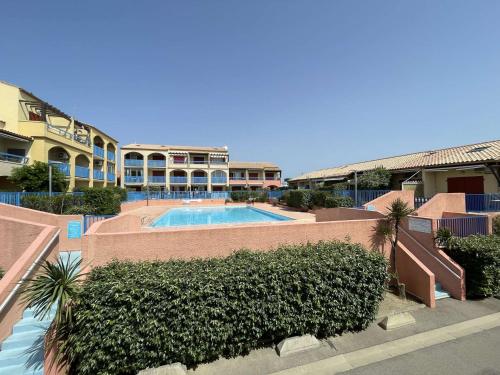 un complexe avec une piscine et quelques bâtiments dans l'établissement Maison 4 pièces - Gruissan GN210-027, à Gruissan