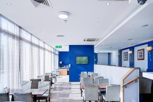 a waiting room with chairs and tables and blue walls at Dancenter near Stoke On Trent former Holiday Inn in Crewe