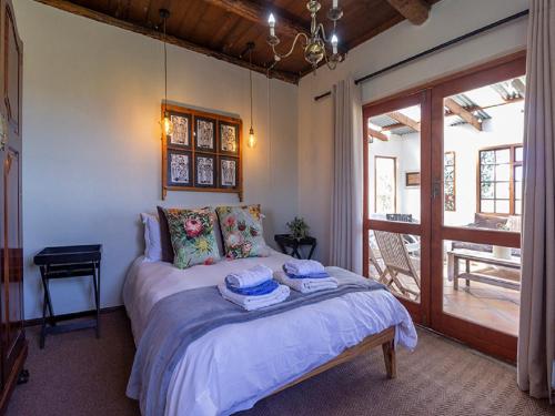 a bedroom with a bed with two towels on it at Beloftebos Farm Cottages in Papiesvlei