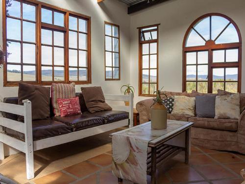a living room with a couch and a table at Beloftebos Farm Cottages in Papiesvlei