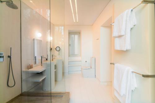 a bathroom with a shower and a sink and a mirror at Plaka Villa with Epic Acropolis Views in Athens
