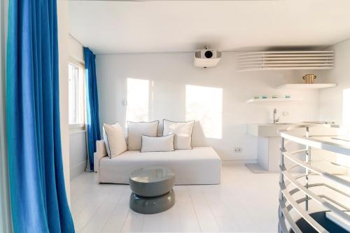a living room with a white couch and blue curtains at Plaka Villa with Epic Acropolis Views in Athens