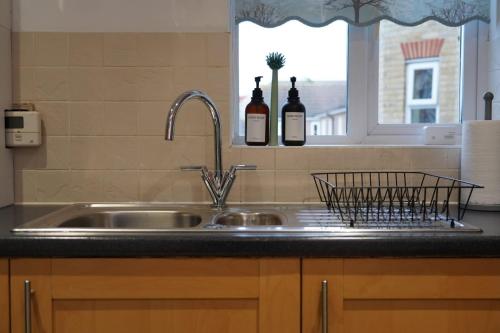 NEW 2-Bedroom - Parking - Ideal4Family في Harold Wood: طاولة مطبخ مع حوض ونافذة