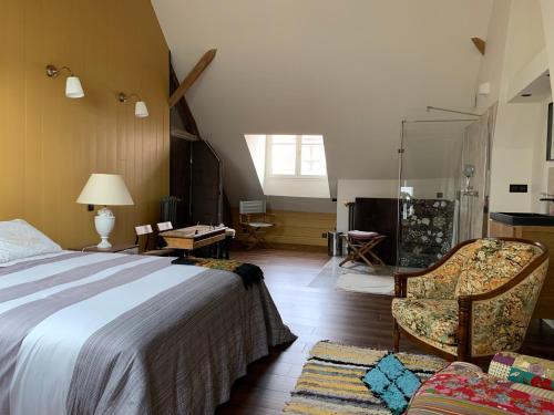 a bedroom with a bed and a chair in a room at Le Nid de Rochefort in Rochefort-en-Yvelines