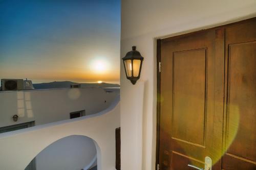 a room with a door and a stool and a window at Ducato Dream jaccuzi Suite Imerovigli Santorini in Imerovigli