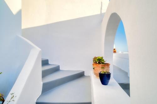 a white staircase with two potted plants on it at Ducato Dream jaccuzi Suite Imerovigli Santorini in Imerovigli