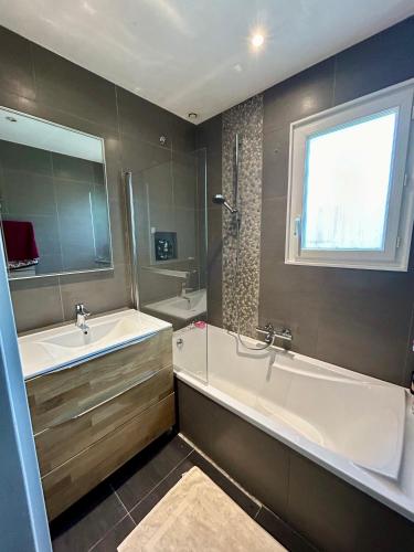 une grande salle de bain avec une baignoire et un lavabo dans l'établissement Pretty air conditioned villa, à Mouans-Sartoux