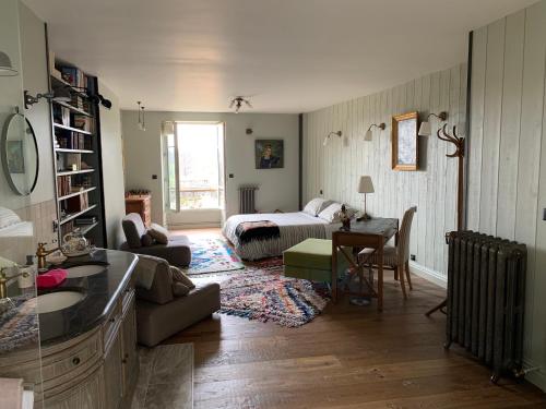 - un salon avec un lit et une chambre avec une table dans l'établissement Le Nid de Rochefort, à Rochefort-en-Yvelines