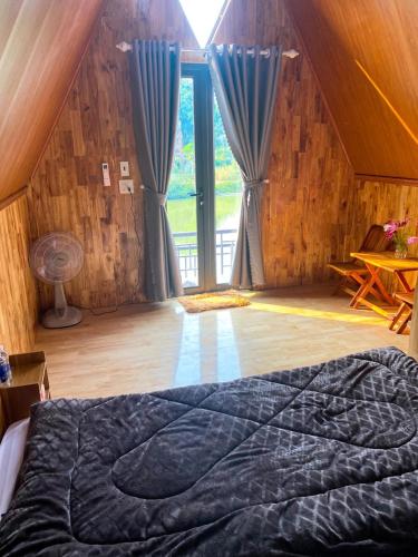 a bedroom with a bed and a large window at Giáp Hoài Homestay Suối Khoáng Nóng Bản Hốc in Yên Bái