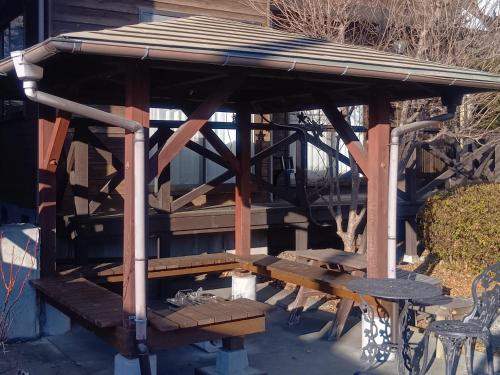 a wooden pavilion with a table and a bench at 貸別荘Lealeaプライベートコテージ in Fujikawaguchiko