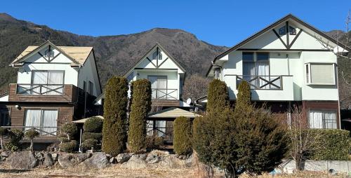 a row of houses in front of a mountain at 貸別荘Lealeaプライベートコテージ in Fujikawaguchiko