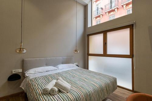 Un dormitorio con una cama con toallas. en Premium Suite by the Turia River 3, en Valencia