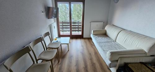 a living room with a couch and a table and chairs at Brenta apartment in Folgarida