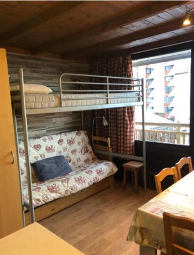 Ce lit superposé se trouve dans un dortoir doté d'un canapé. dans l'établissement residence Lac Blanc, à Val Thorens