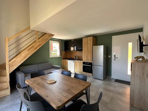 une cuisine et une salle à manger avec une table et des chaises en bois dans l'établissement Mini villa T3 de 48m2, à Lecci