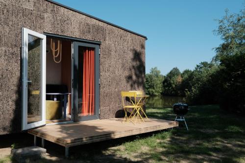 a building with a door and chairs on a porch at kleiner Heidesee in Versmold