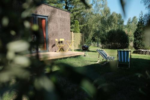a yard with two chairs and a table and a grill at kleiner Heidesee in Versmold