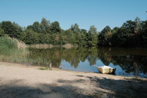a boat sitting on the shore of a lake at kleiner Heidesee in Versmold