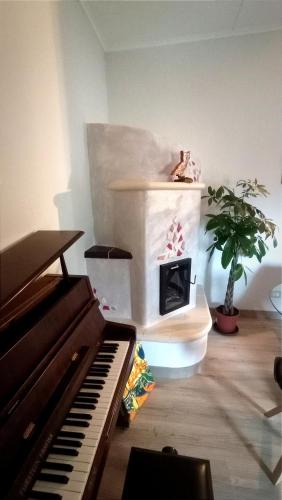 a piano sitting in a room with a plant at I Mosaici Guesthouse Luxury Apartment in Ronco Scrivia
