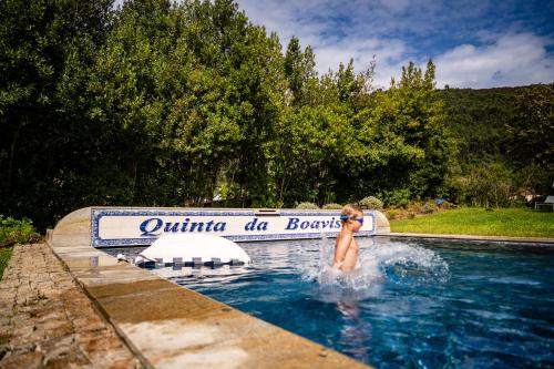 a man in a swimming pool at a resort at Vinte-Quinta da Boavista in Ponte de Lima