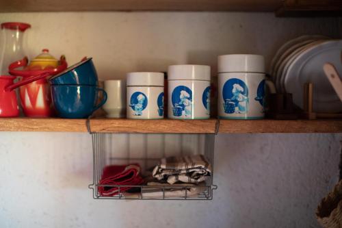 a shelf with coffee cups and plates on it at HIS-a za 2 in Dragatuš