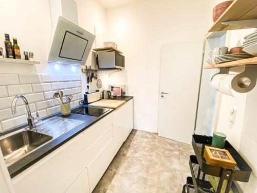 a small kitchen with a sink and a microwave at Apartments "Am Rheinorange", Netflix & Prime in Duisburg