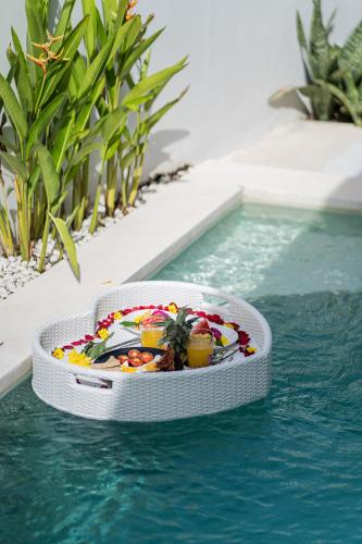 a bowl of food in the water next to a swimming pool at Salthouse Villa Uluwatu in Uluwatu
