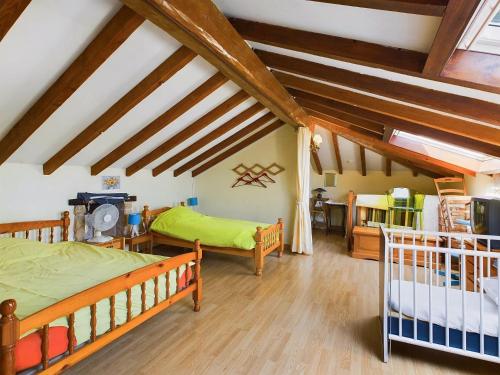 a attic bedroom with two bunk beds and wooden beams at Séjour authentique-Piscine Privée Chauffée- Spa et Nature in Beauville
