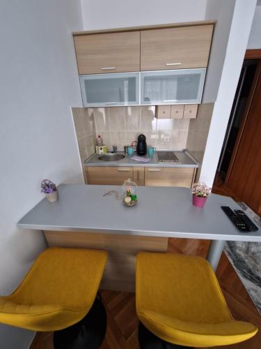 een keuken met twee gele stoelen en een aanrecht bij Riverview in Podgorica