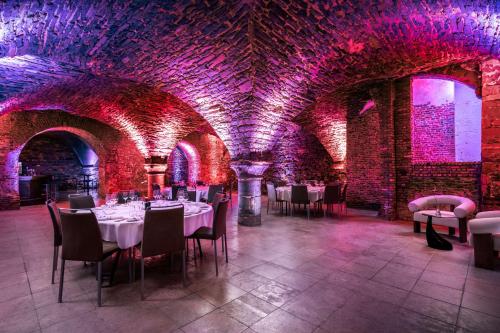 a dining room with tables and purple lights at NH Collection Gent in Ghent